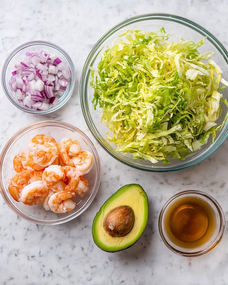 A clear glass bowl filled with shredded light green and yellow lettuce sits on a white marbled surface. Nearby, a halved avocado with creamy light green flesh and a large brown pit rests beside a small glass bowl of bright orange-pink cooked shrimp. Another small glass bowl holds chopped red and white onions, and a fourth glass container has a light brown liquid dressing. The setup is clean and colorful, showing fresh ingredients ready to be combined. photo taken with an iphone --ar 4:5 --v 7
