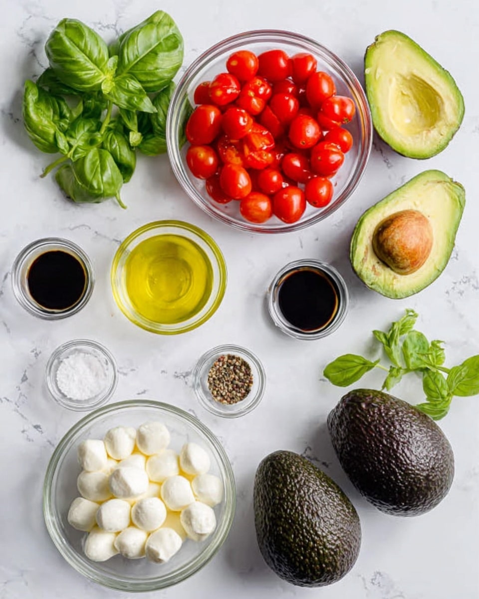 The image shows several ingredients on a white marbled surface. There are three whole dark green avocados, one avocado cut in half showing its bright green inside and brown seed, a clear bowl of small red cherry tomato halves, a clear bowl of white mozzarella balls, a small glass bowl of yellow olive oil, a small glass bowl with a mix of salt and pepper, a small glass bowl of dark balsamic vinegar, and a bunch of fresh green basil leaves. Everything is arranged neatly and spread out evenly. photo taken with an iphone --ar 4:5 --v 7