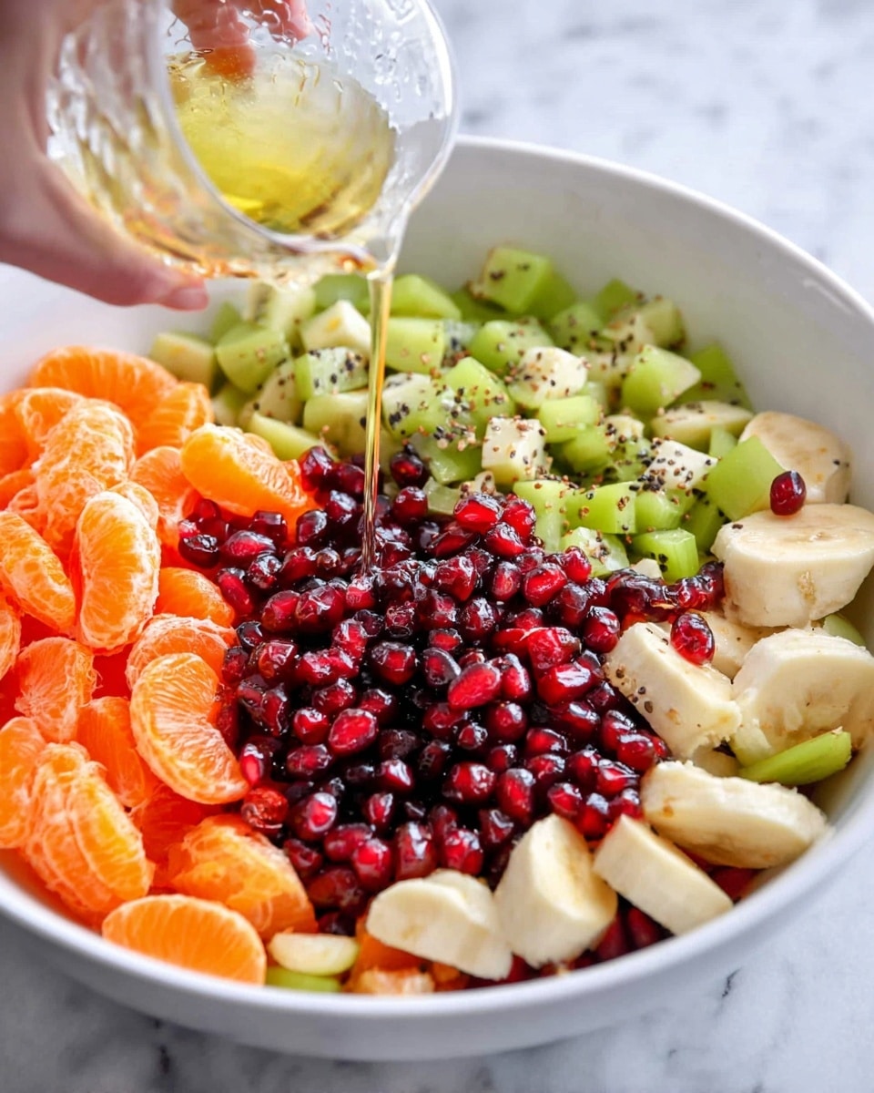 A white bowl filled with five layers of fresh fruit arranged separately: bright orange mandarin slices on the left, light green chopped kiwis behind the mandarins, dark red pomegranate seeds piled in the center being drizzled with a light yellow liquid from a clear glass held by a woman's hand above, pale yellow banana slices on the right, and light green chopped pears at the bottom. The bowl sits on a white marbled surface, adding a clean and fresh look. photo taken with an iphone --ar 4:5 --v 7