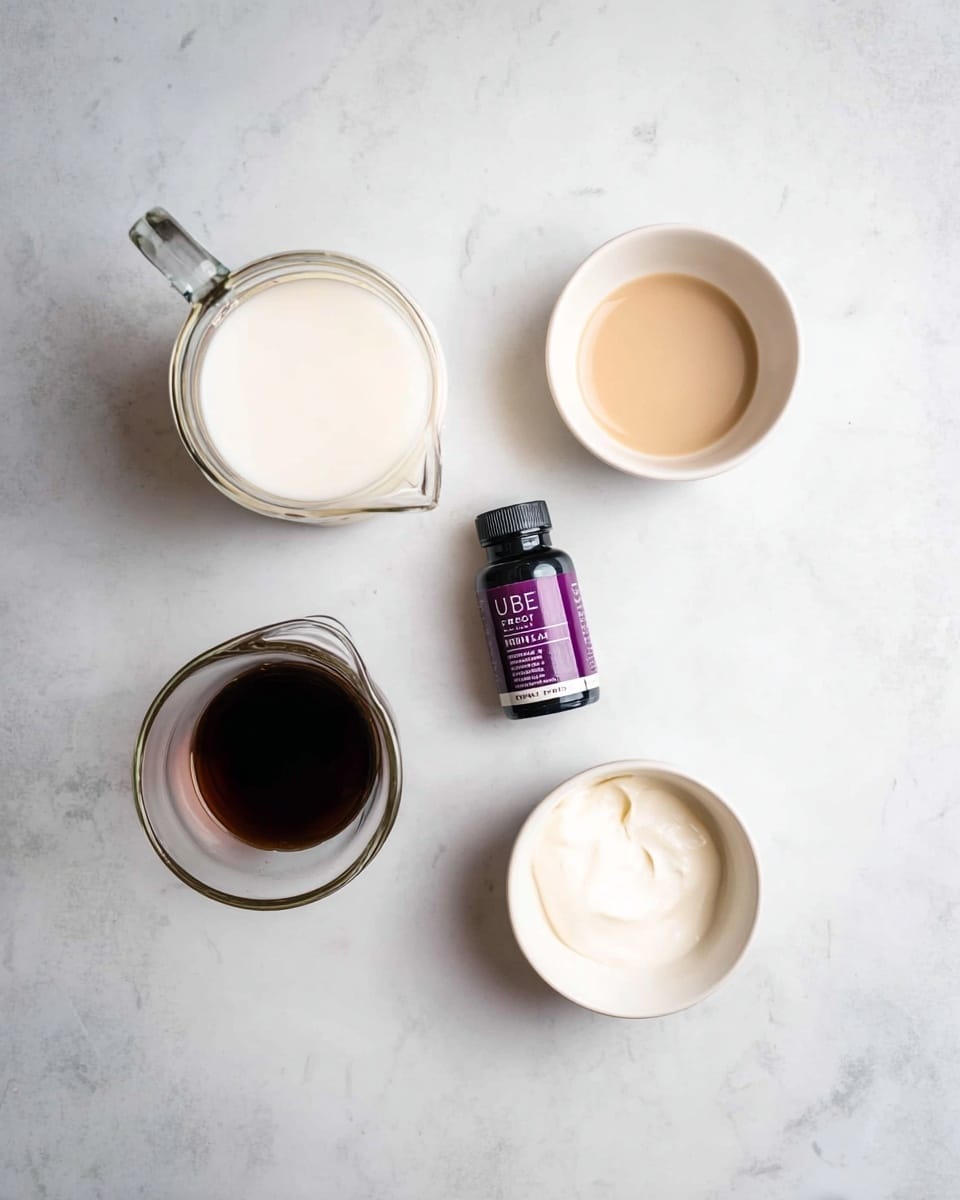 A top view of five items arranged on a white marbled surface: at the top left is a glass jug filled with white cream, to the right of it is a small white bowl holding a light tan liquid, in the center is a small dark purple bottle labeled