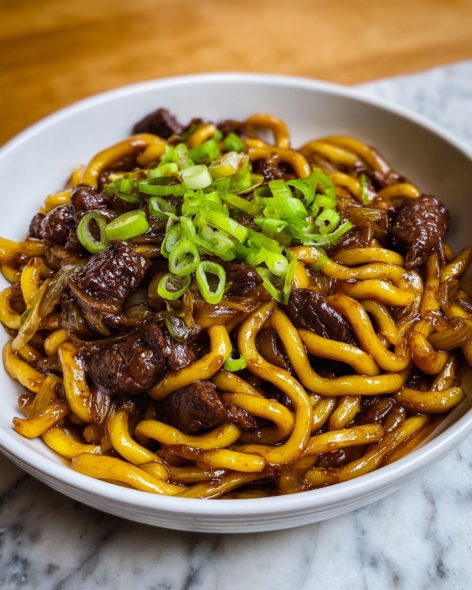 A white bowl filled with thick, twisted yellow noodles coated in a dark, shiny sauce forms the base layer, mixed with small, tender chunks of dark brown beef and translucent, soft pieces of cooked onion. The top layer is sprinkled with bright green onion slices, adding fresh color contrast. The bowl sits on a white marbled textured surface, and the image has warm natural light. photo taken with an iphone --ar 4:5 --v 7