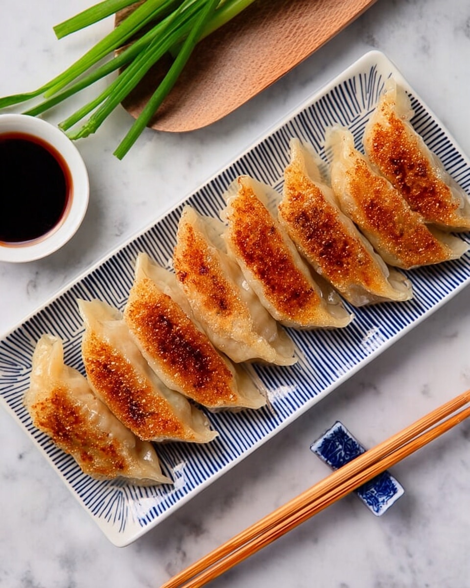 A white rectangular plate with blue lines holds six golden brown pan-fried dumplings placed side by side in a row. Each dumpling has a crispy texture on one side with slightly uneven browned spots, while the other side appears soft and light beige. To the top left of the plate, there is a small white round dish filled with dark dipping sauce. A pair of light wooden chopsticks rests on the white marbled surface next to the plate, with a small blue and white chopstick holder beneath them. To the left side of the image, there are fresh green onions lying on the white marbled surface, adding a touch of color. Photo taken with an iphone --ar 4:5 --v 7